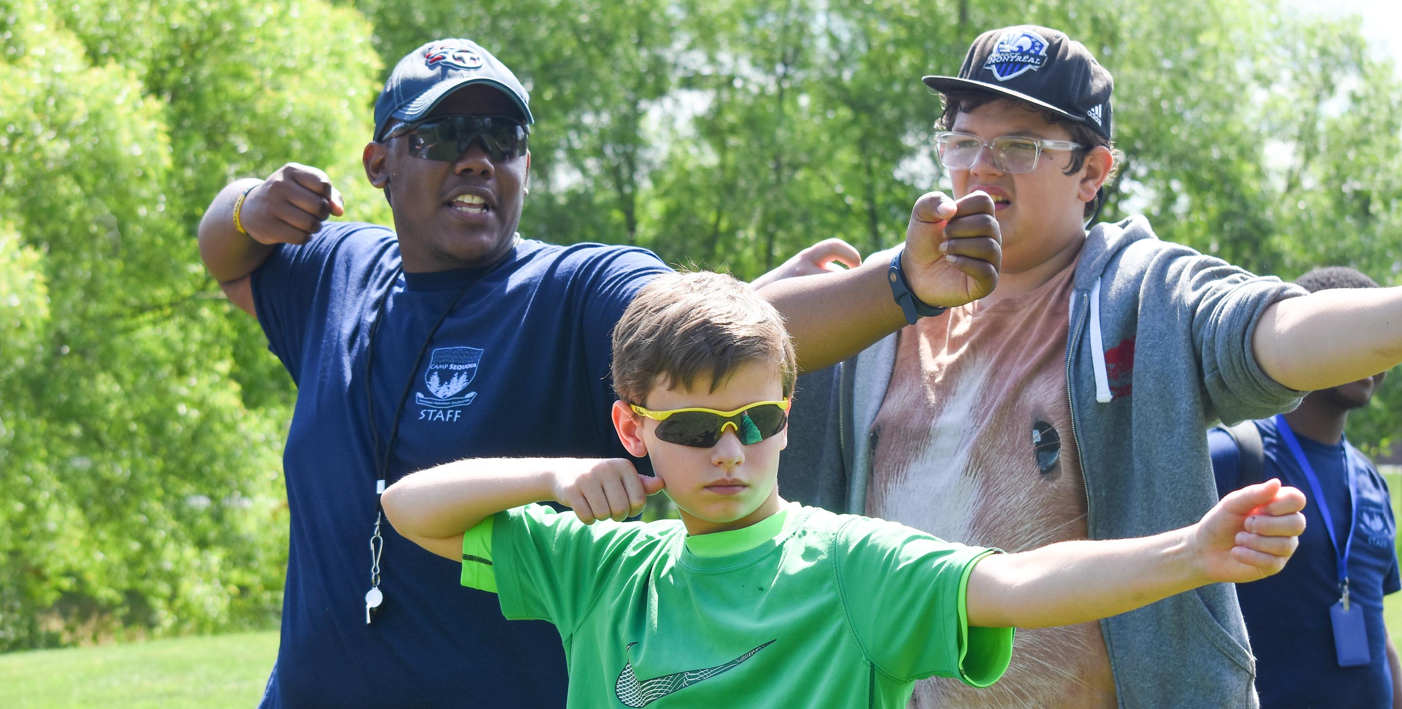 Staff teaching campers archery