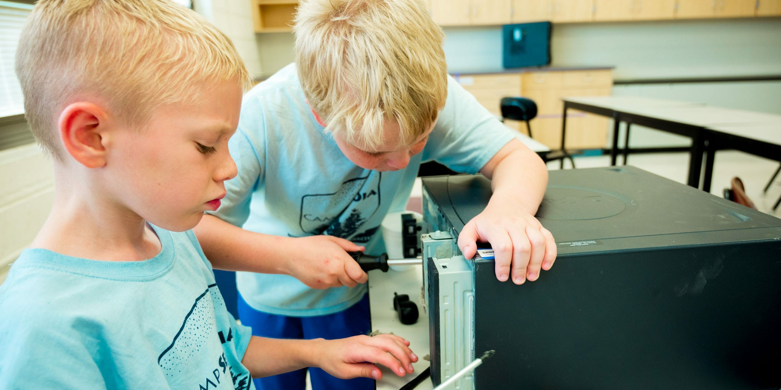 Two siblings working on computers