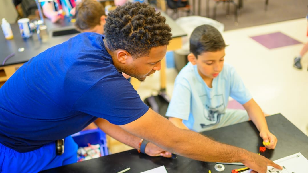 Staff helping camper with STEM project