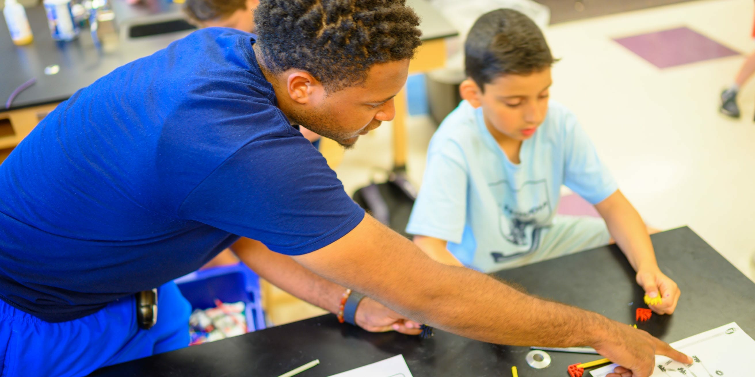 Staff helping camper with STEM project