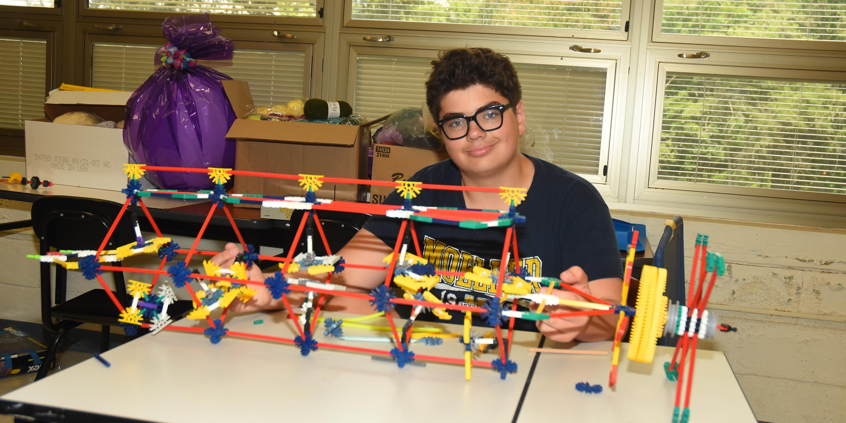 Camper smiling with his STEM project