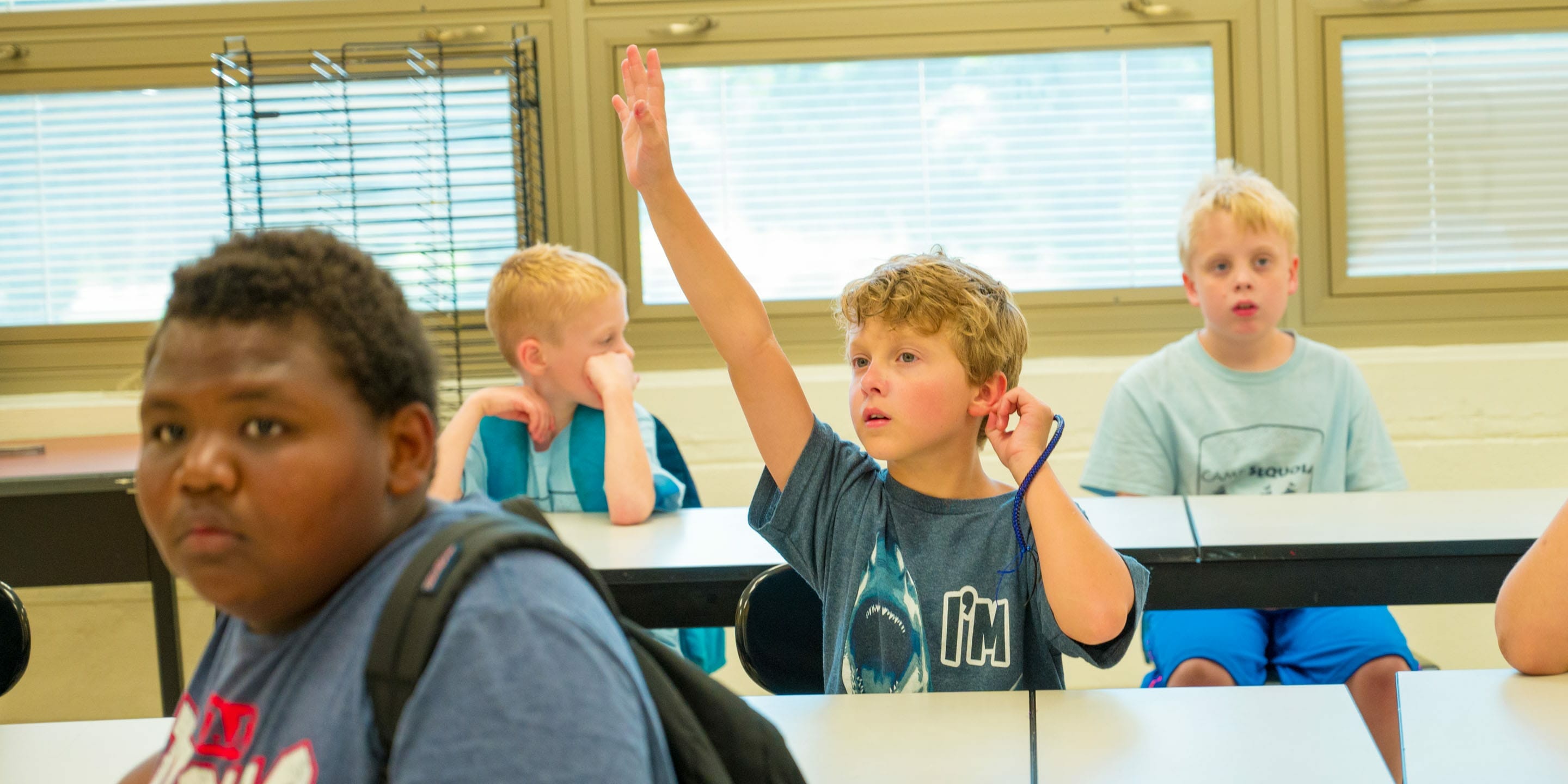Camper raising his hand in the classroom